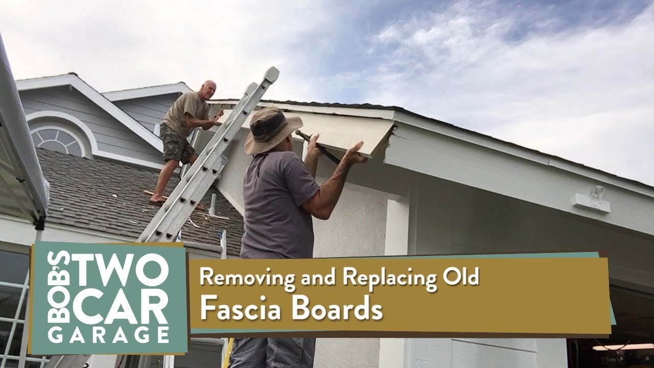 Worker fitting fascia boards on residential roof